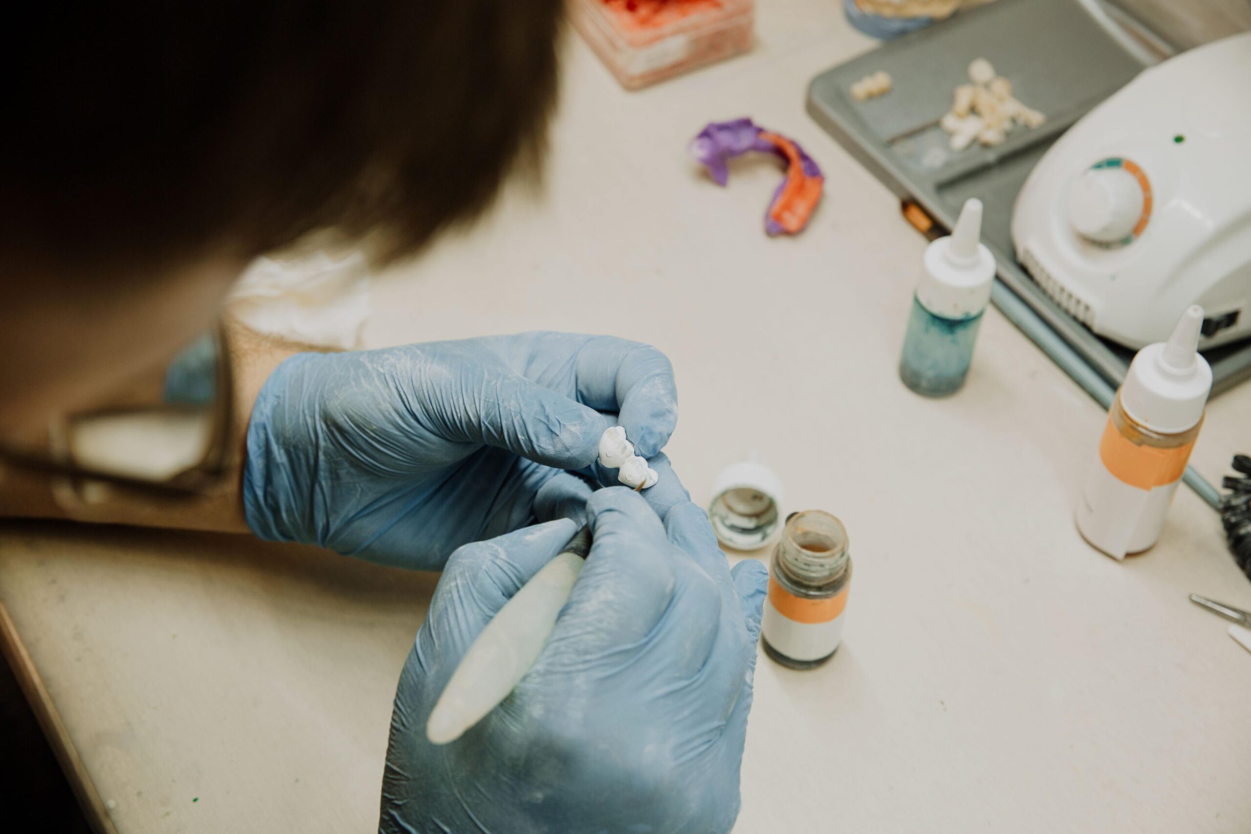 Dental technician hand-crafting a crown restoration at the lab workbench